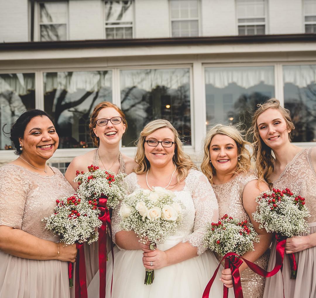 Gold bridesmaids with red bouquets