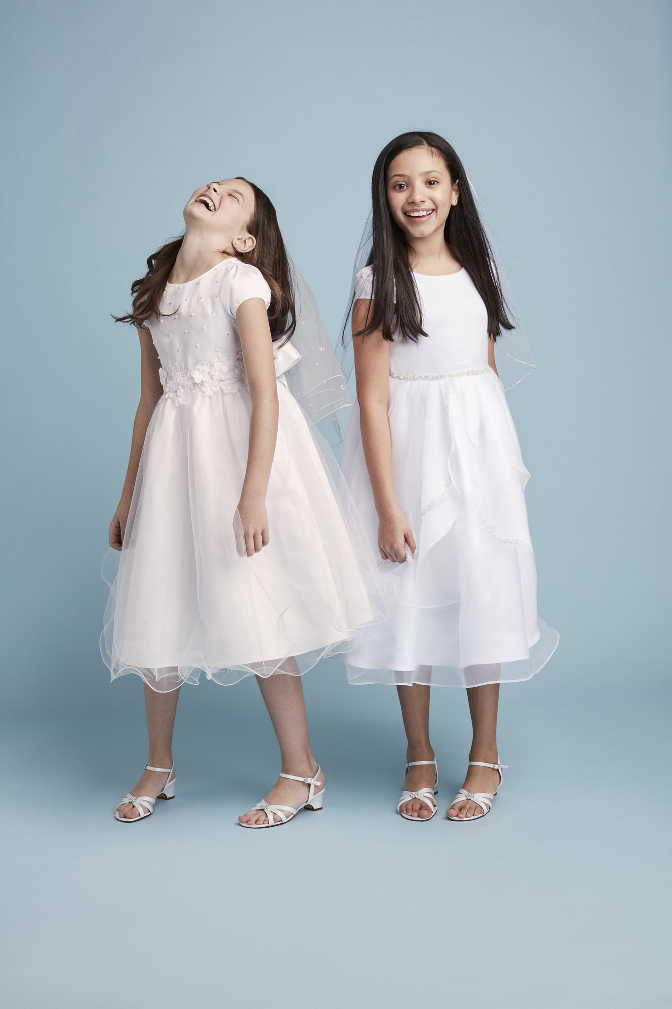 Two girls smiling in communion dresses from David's Bridal