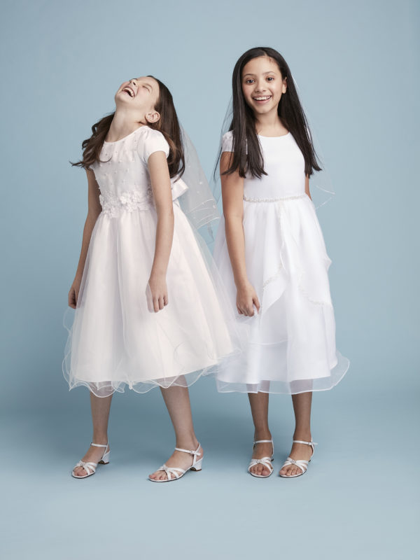 Two girls smiling in communion dresses from David's Bridal