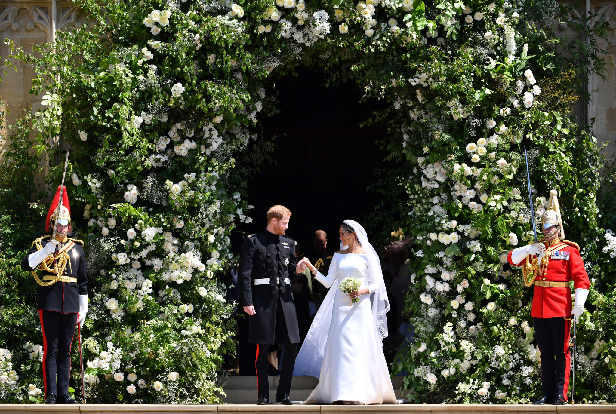 Meghan Markle and Prince Harry hand in hand in front of Buckingham Palace after their wedding ceremony