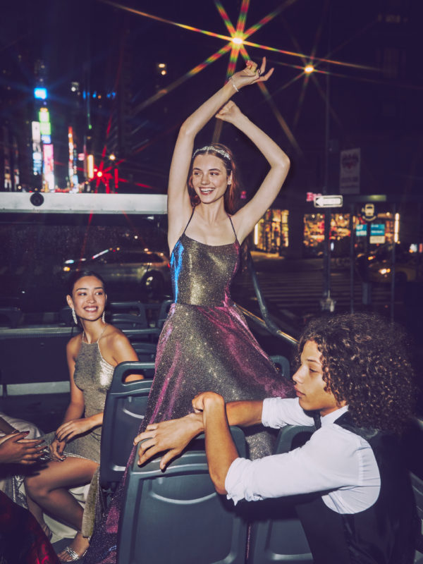 Girl in multicolored ball gown prom dress on bus in New York City