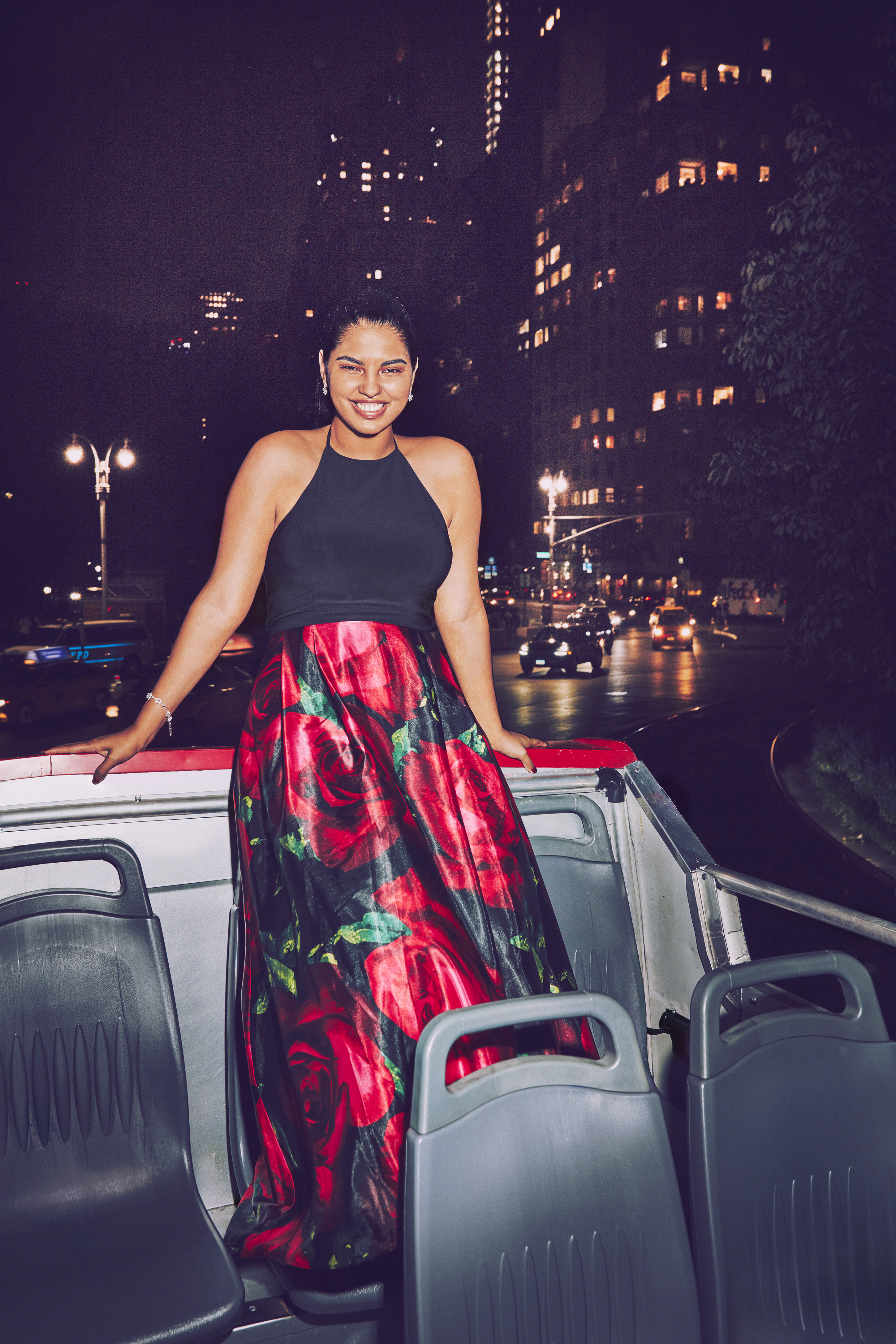 Girl in black and red rose flower print dress on bus