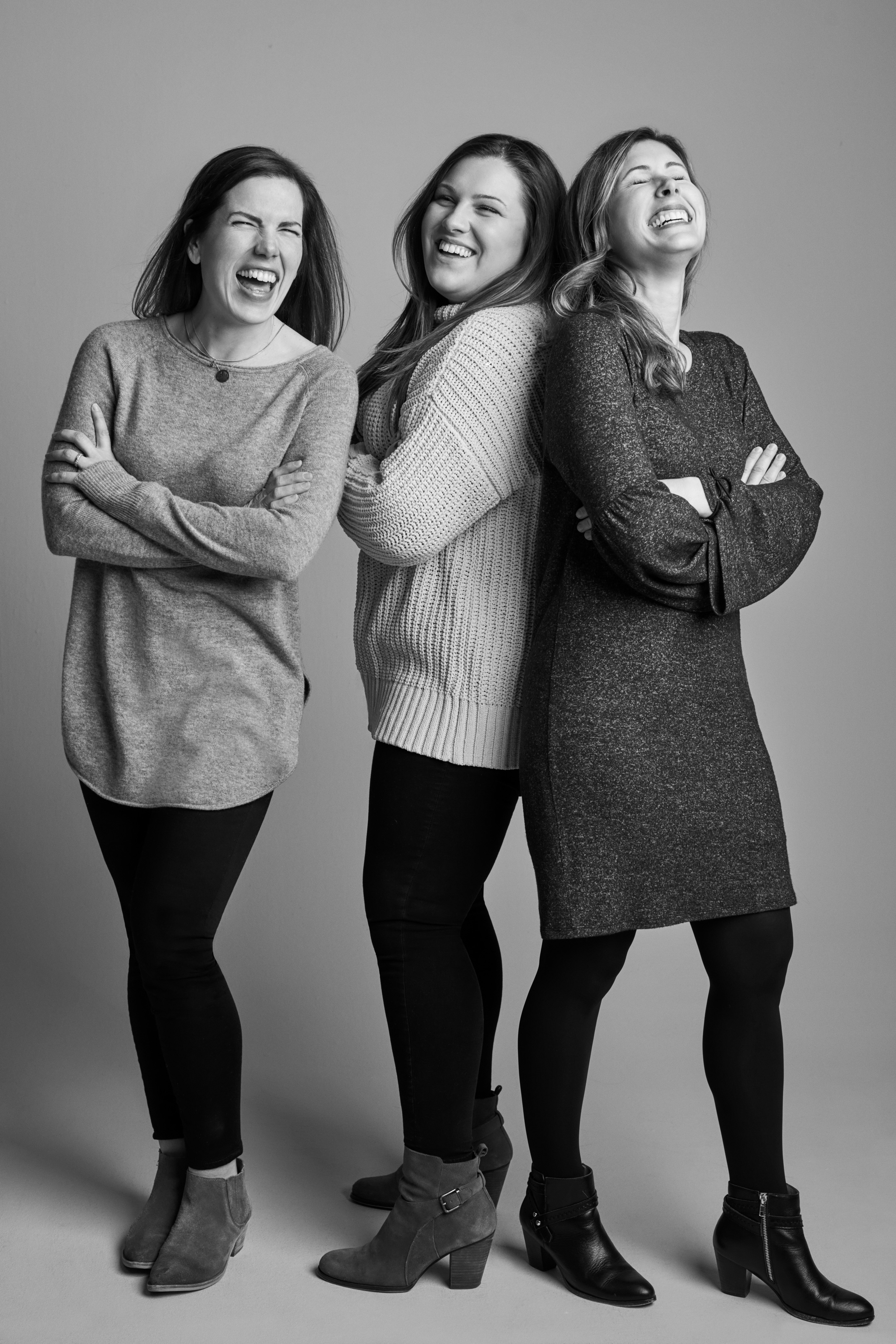 Three women from David's Bridal's PR and Social Media team laughing in a photo studio setting)