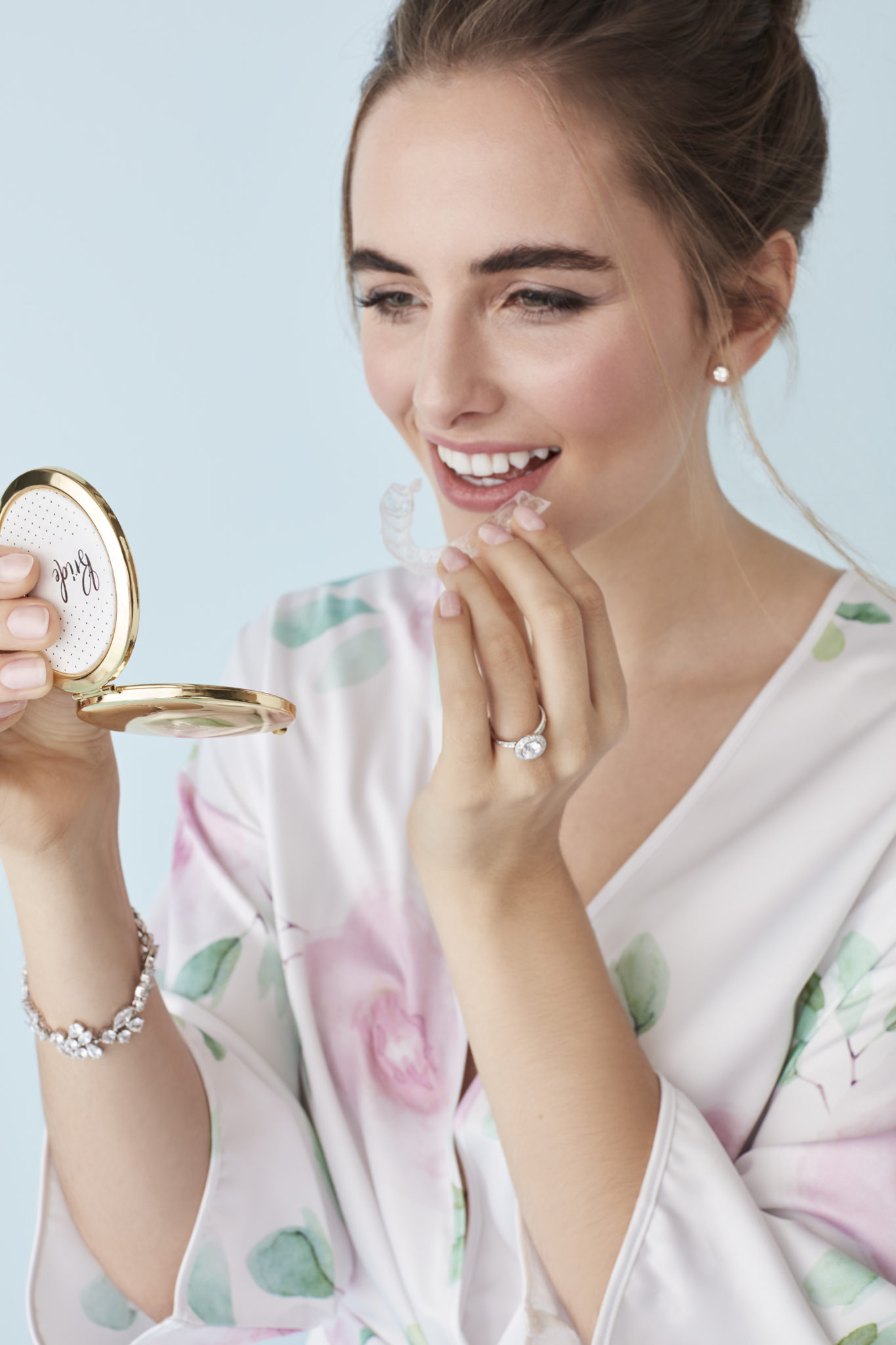 bride with teeth aligning tray and compact mirror