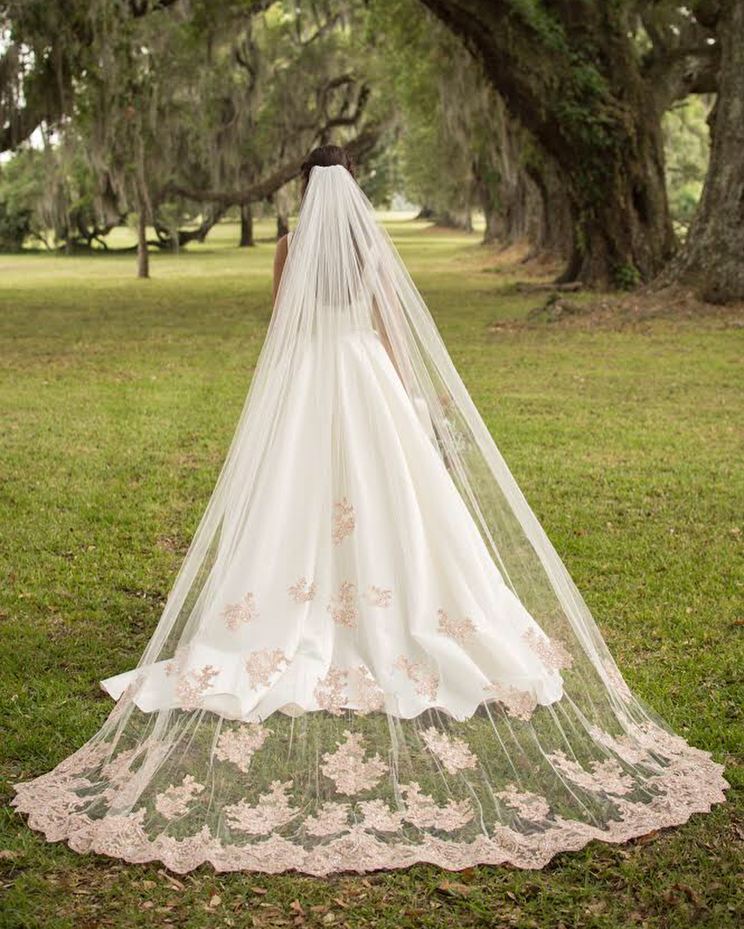 Bride in a rose gold lace cathedral veil on grass | | Insta-Worthy Veils