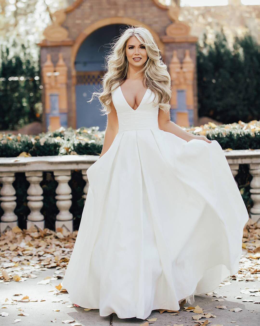 Bride in a plunging V-neck ball gown in a garden setting.