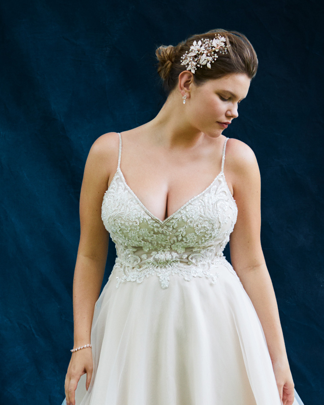 woman in spaghetti strap beaded wedding dress looking down