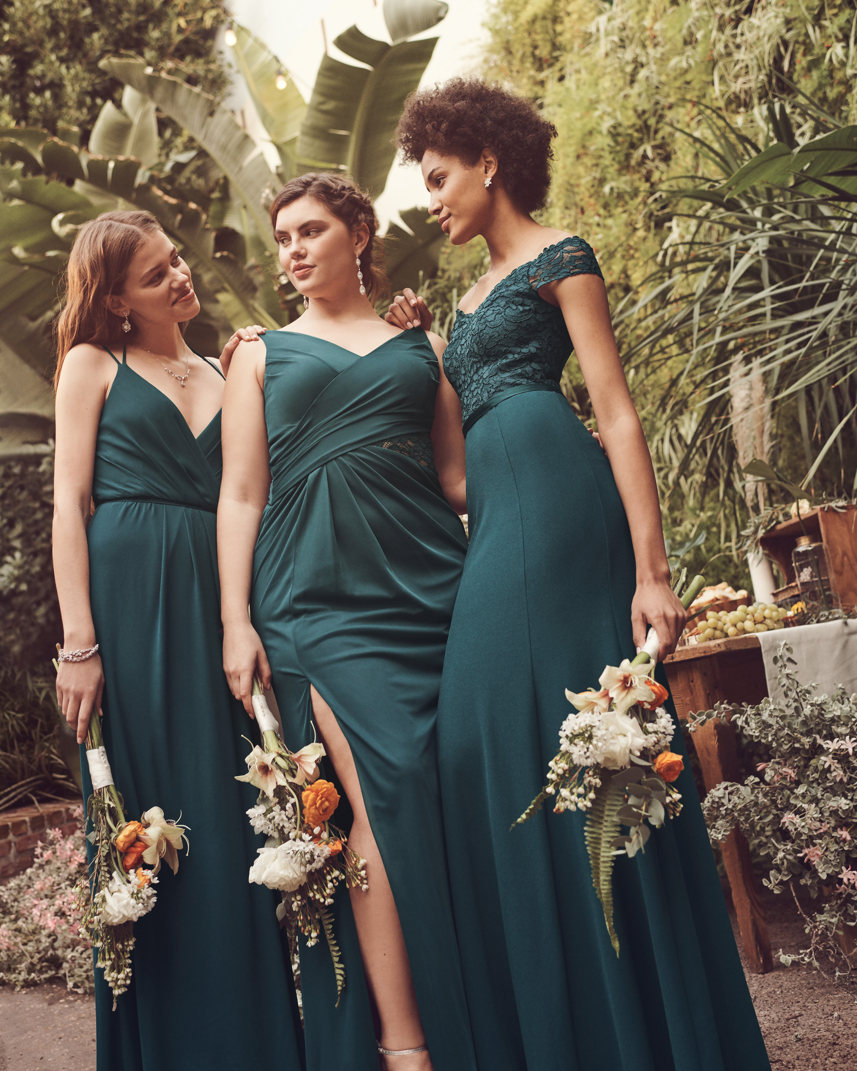 Three bridesmaids in long gem green bridesmaid dresses