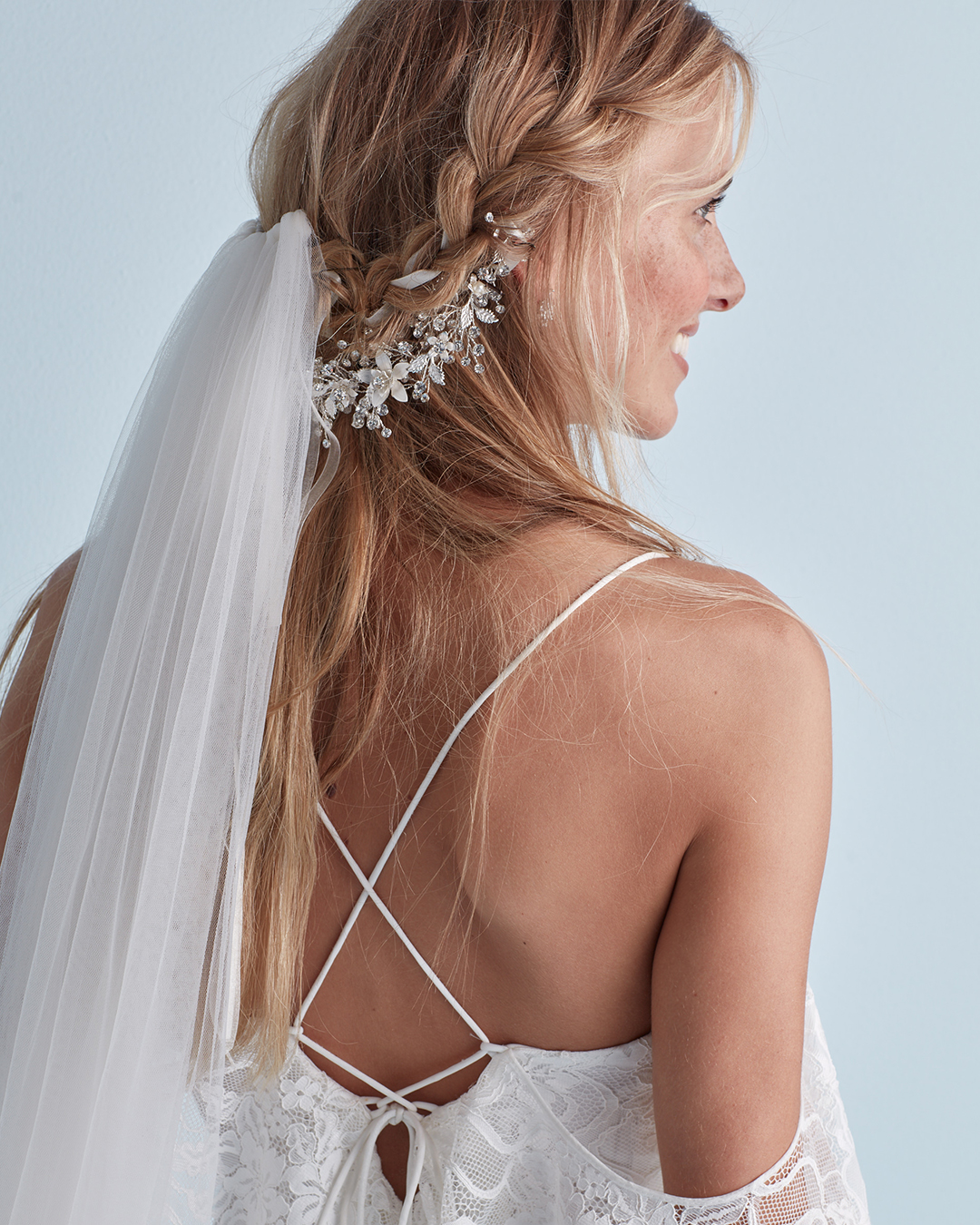 Wedding hairstyle with braid, crystal headband, and veil