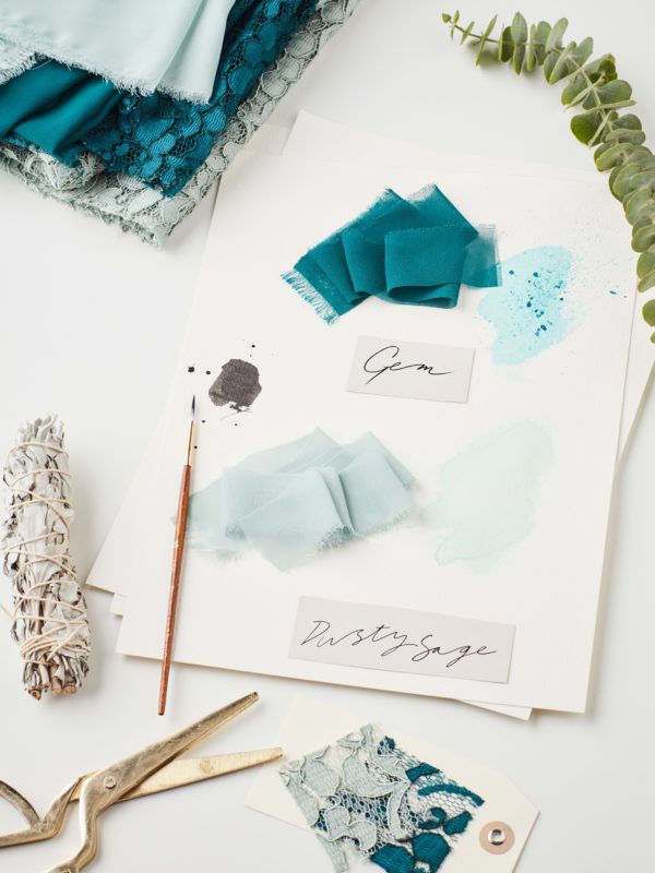 Green bridesmaid color swatches on design table
