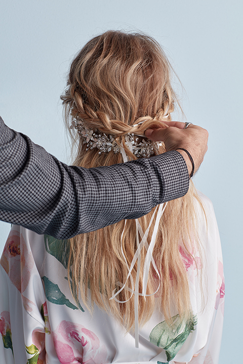 Hair stylist braiding ribbon into hair