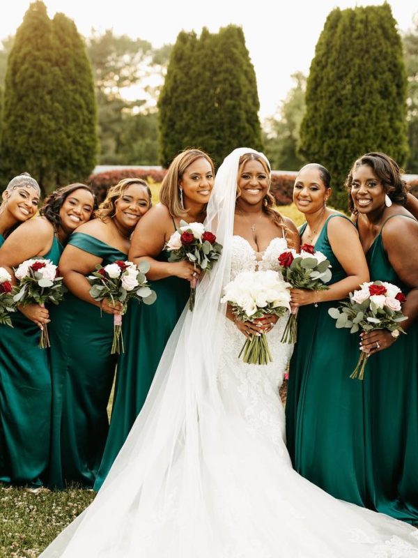 Bride and bridesmaids smiling and holding hands