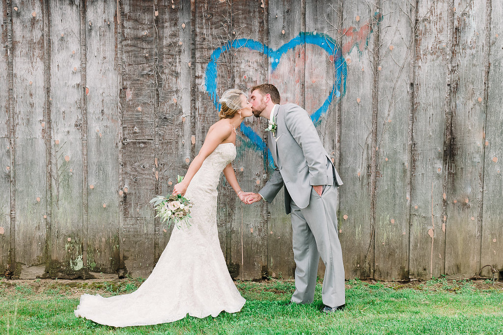 Bride and Groom kiss in front of blue heart