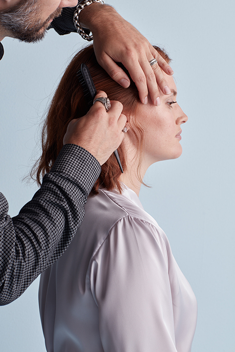 Hair stylist combing hair