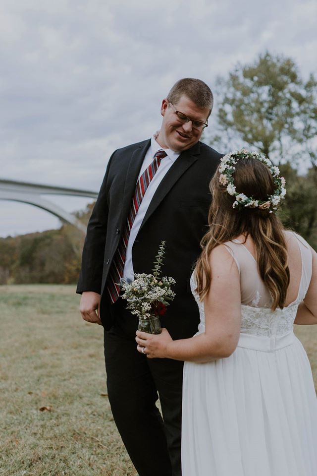 Real bride Jaymee holds bouquet while embracing groom Kenny. 