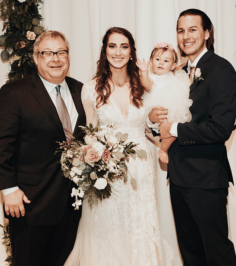 Bride and groom with their infant bride and wedding officiant. 