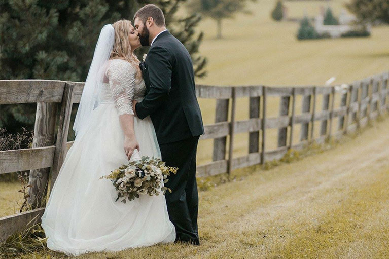 Bride and Groom kissing with bouquet in hand