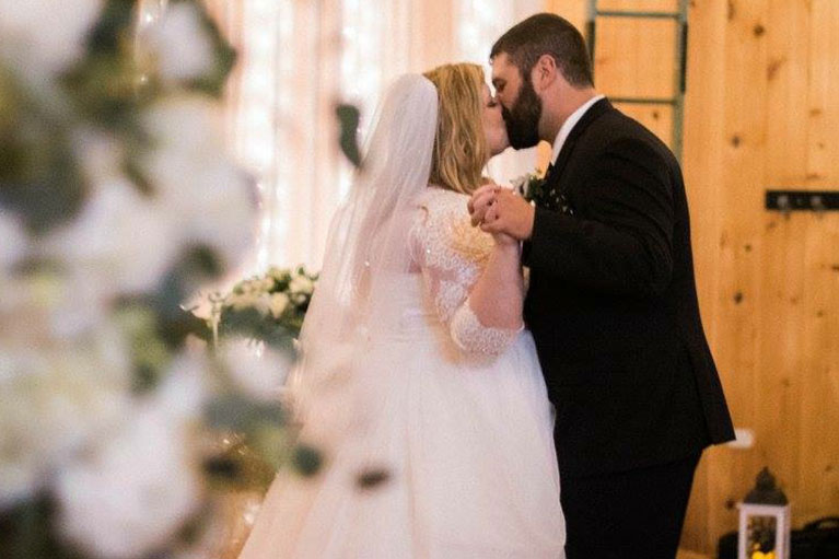 Bride and groom holding hands and kissing