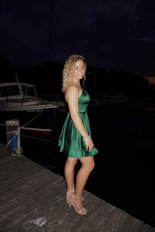 Girl in short green satin homecoming dress