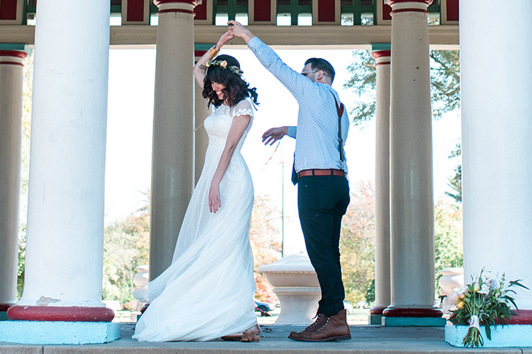 Groom twirling bride in long white dress and flower crown