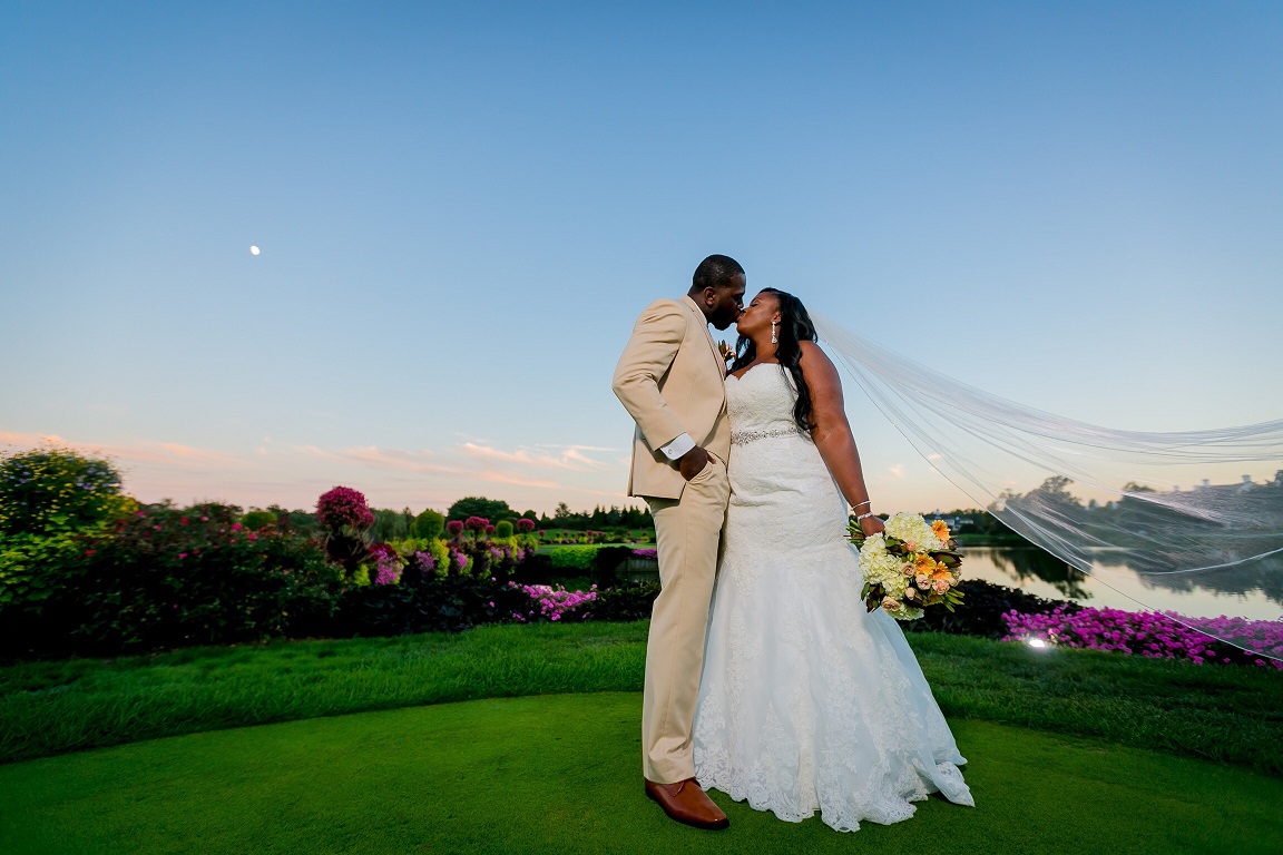 Real bride and groom kiss at sunset