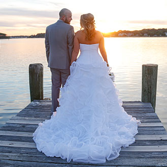 Bride and groom holding hands at sunset on the dock