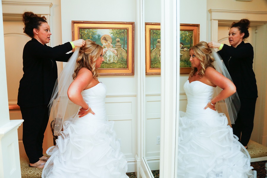 Bride gets ready in the room and puts on veil