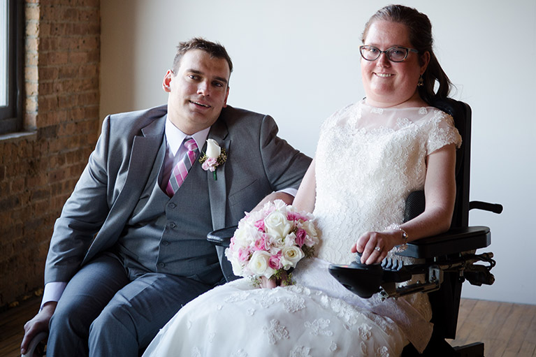 Groom and bride in wedding attire in wheelchairs