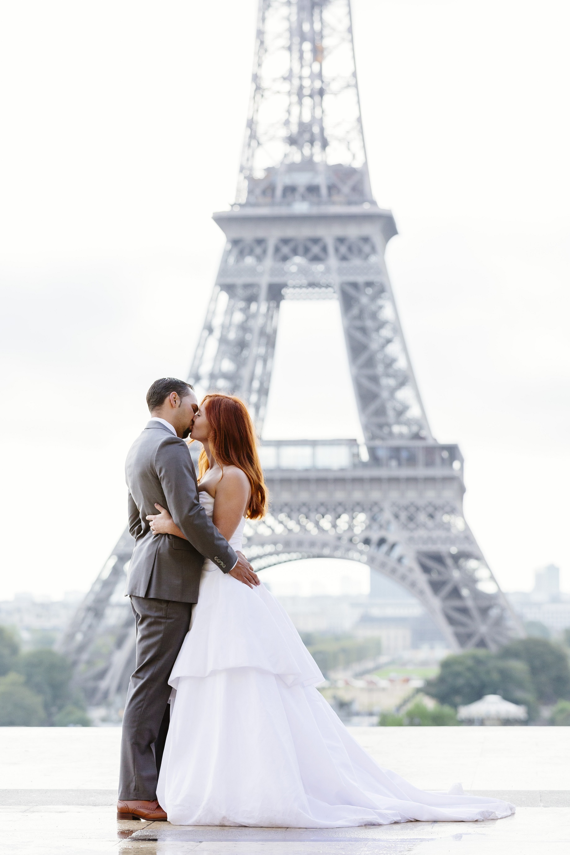 Bride Emily and Groom TJ kiss in front of the Eiffel Tower.