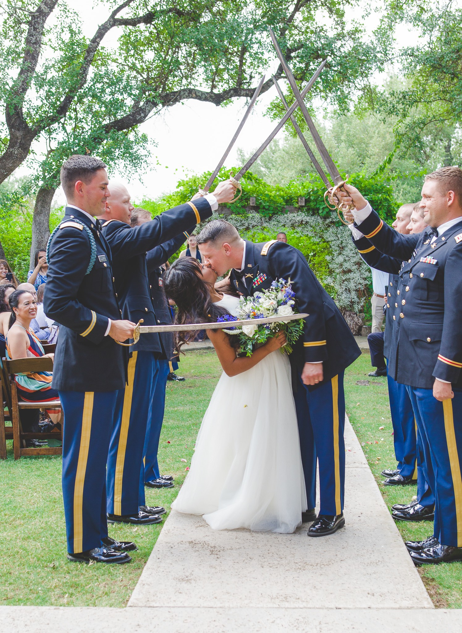 Bride and Groom kissing under military saber arch