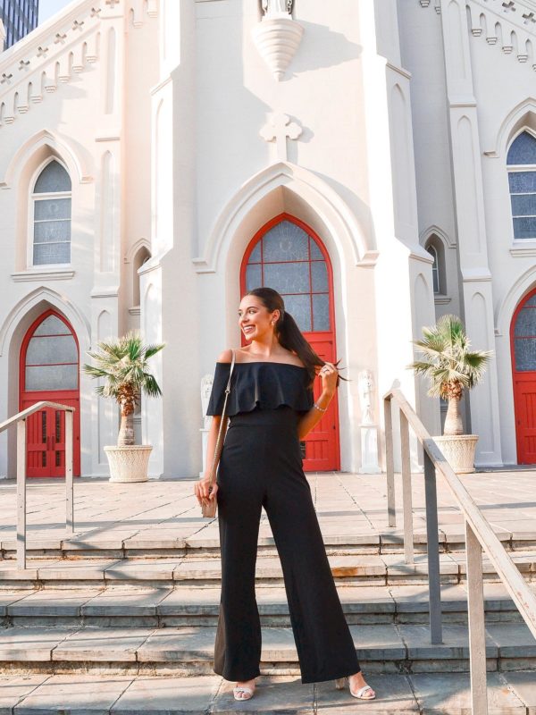 College Ambassador wearing black jumpsuit with full pant legs and off the shoulder top