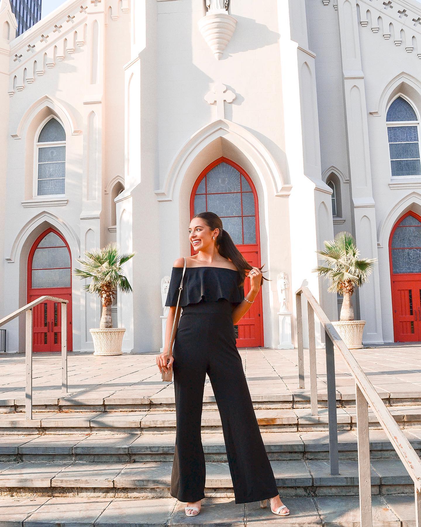 College Ambassador wearing black jumpsuit with full pant legs and off the shoulder top