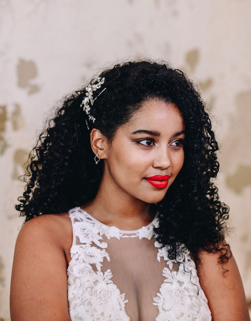 Bride with side swept wedding hairstyle for curly hair