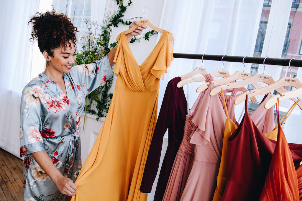 Bride looking at the fabric of a bridesmaid dress