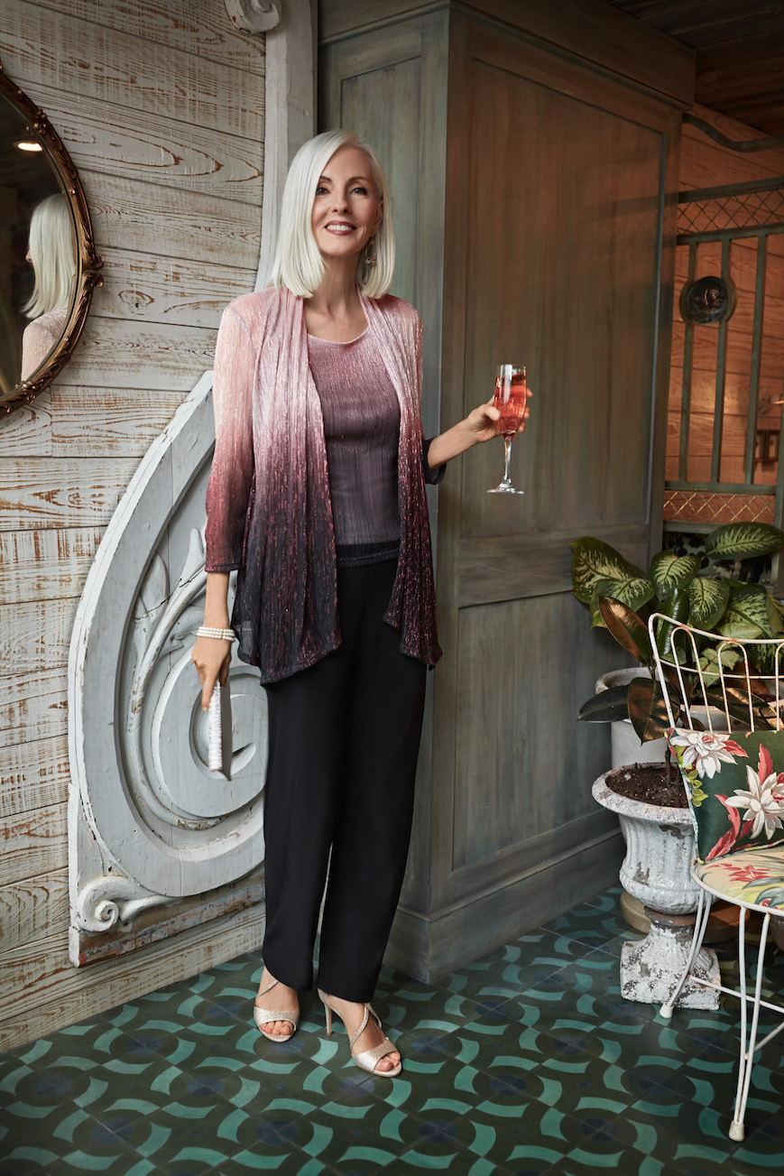 Mother of the bride in an ombre pantsuit holding a wine glass