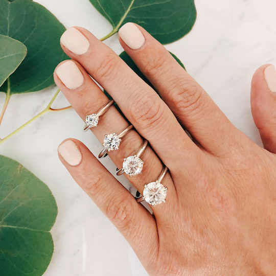 Stack of solitaire wedding rings on hand