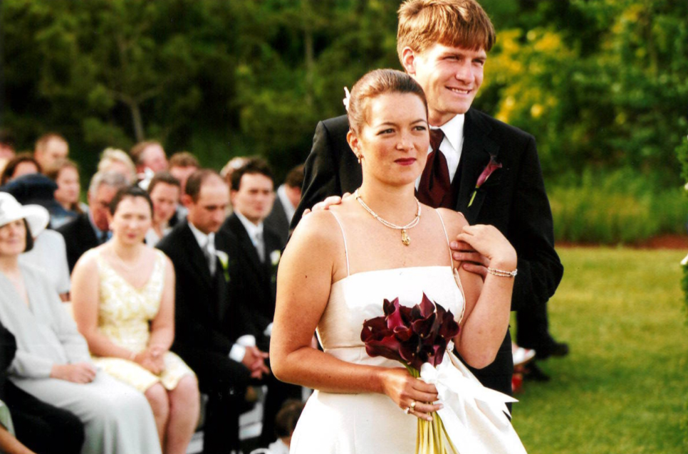 Laura and Trey standing side by side at their quaint wedding.