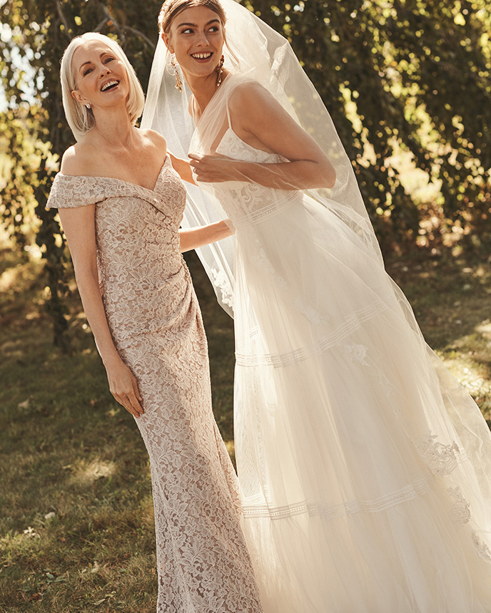 Mom and bride smiling in long dresses