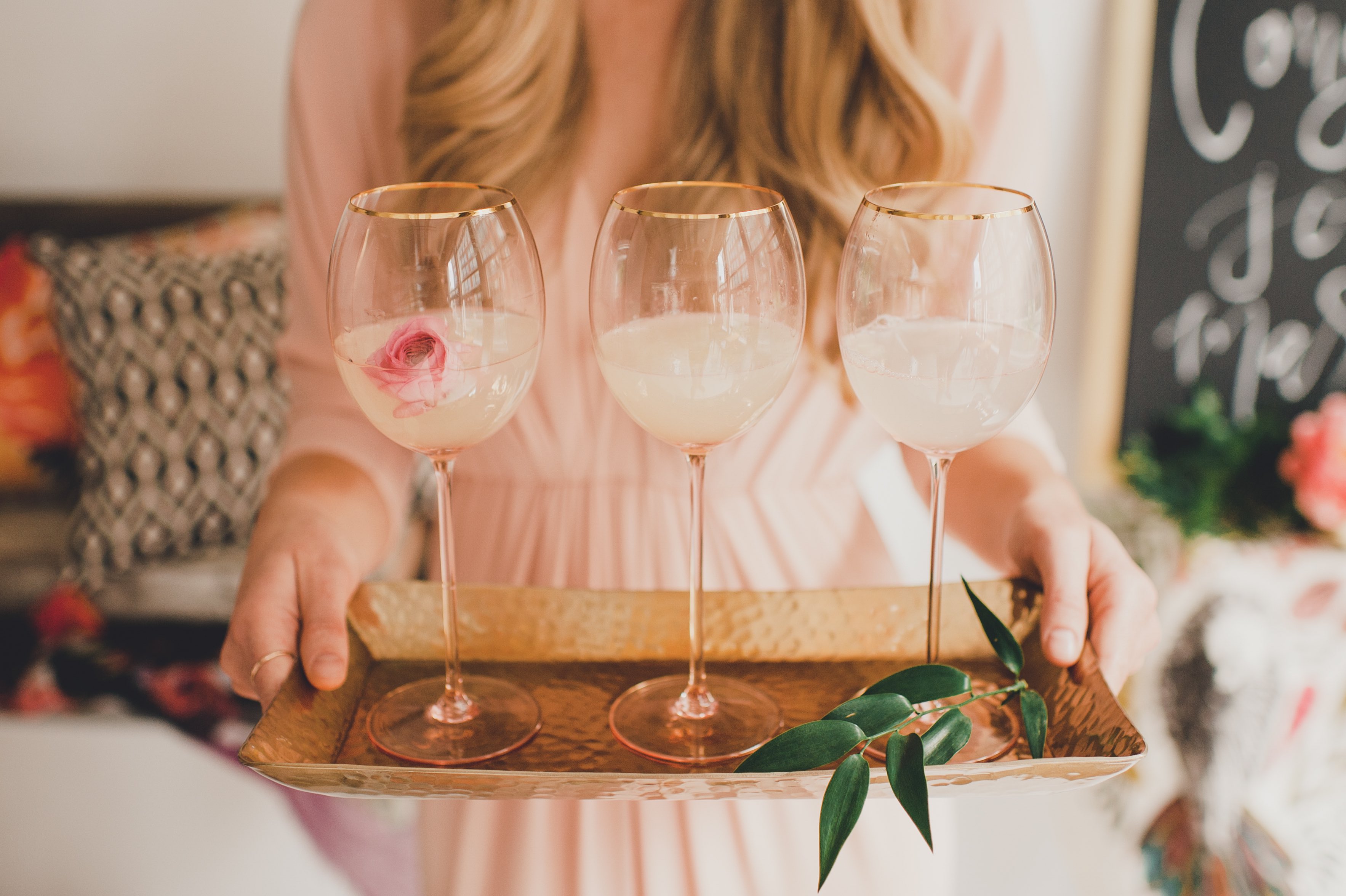 woman holding tray of wine glasses