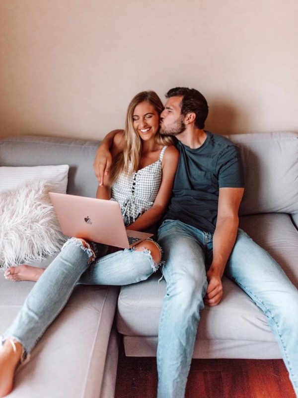 Woman and man sitting on couch with laptop