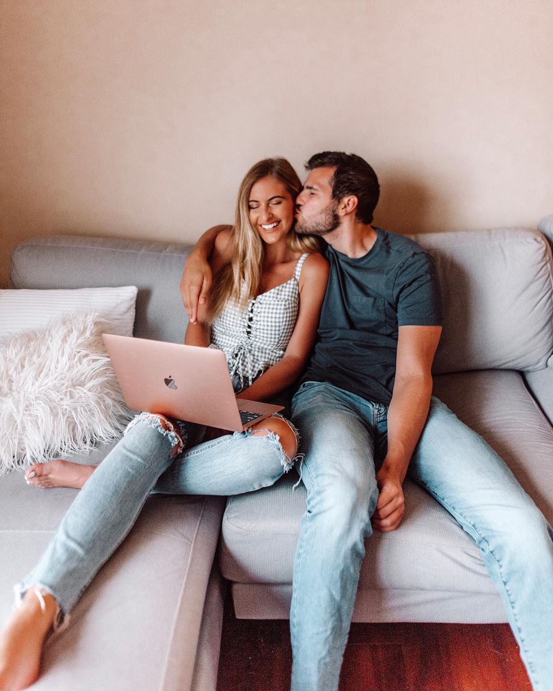 Woman and man sitting on couch with laptop