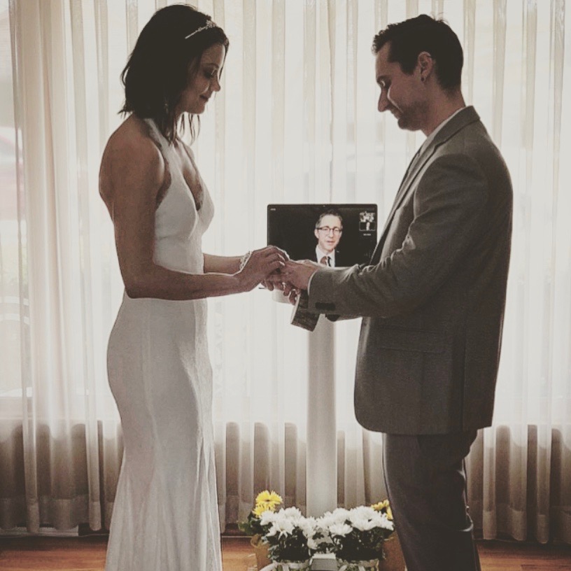 A couple being wed virtually in their living room.