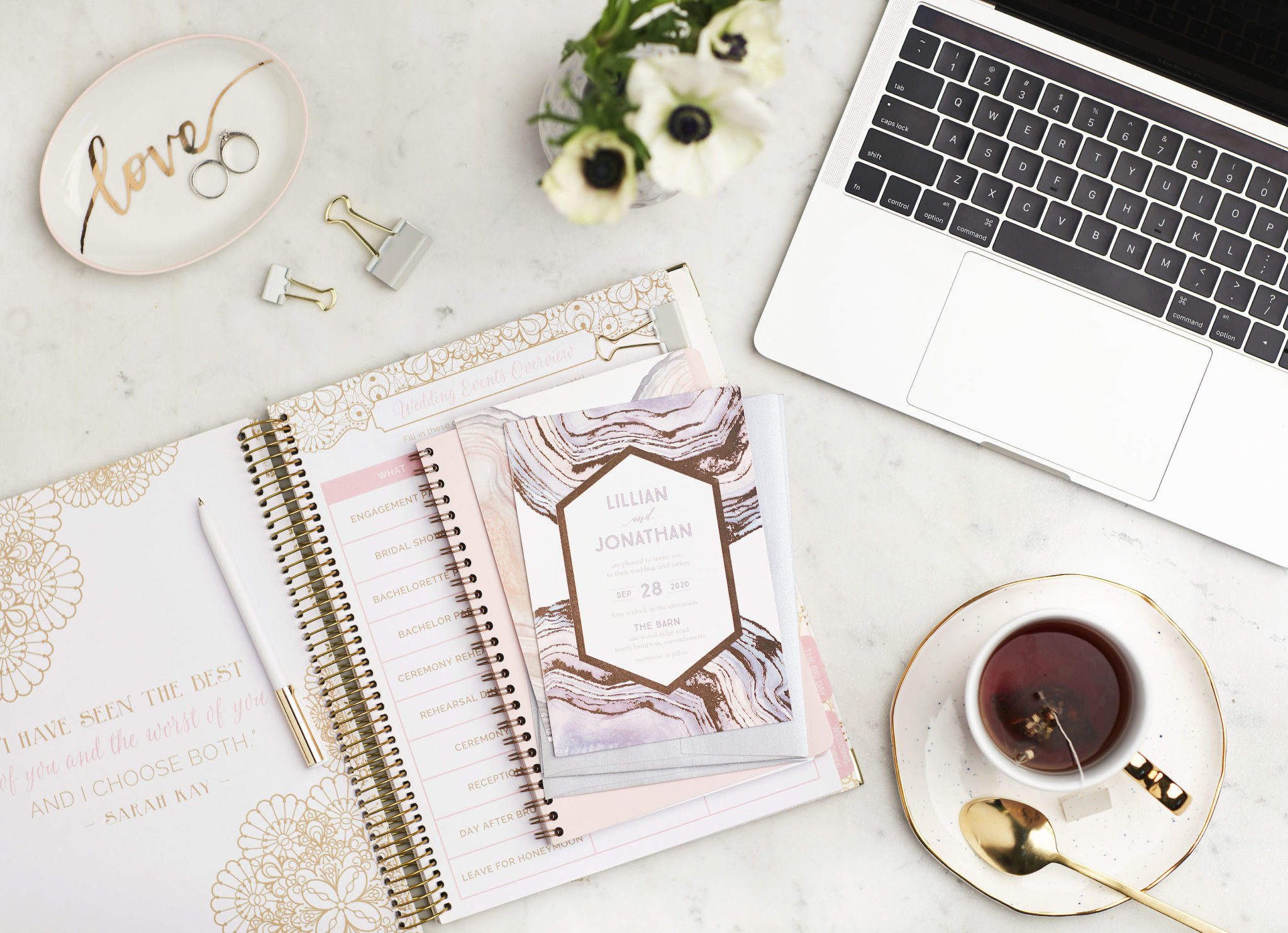 wedding invitation and planner on desk