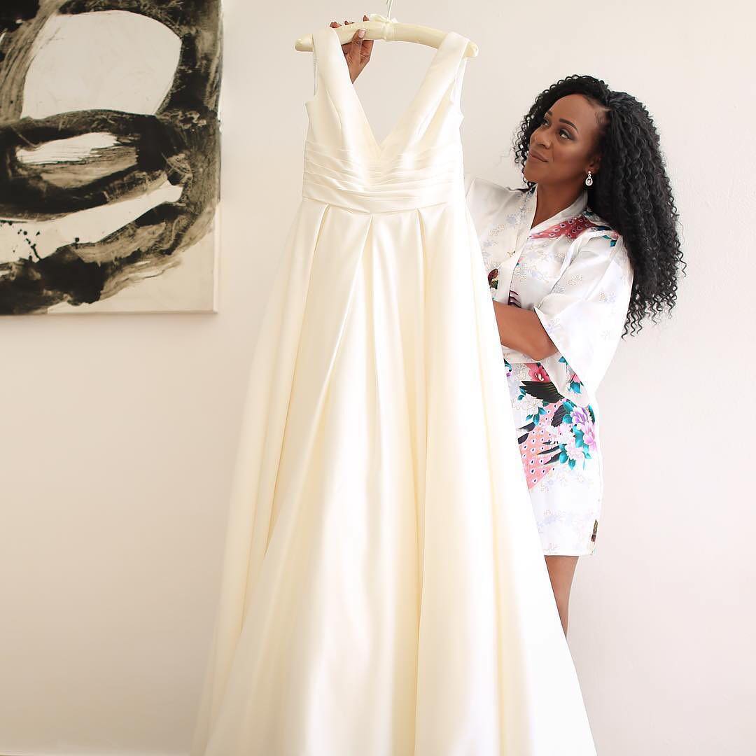 Bride holding dress on hanger
