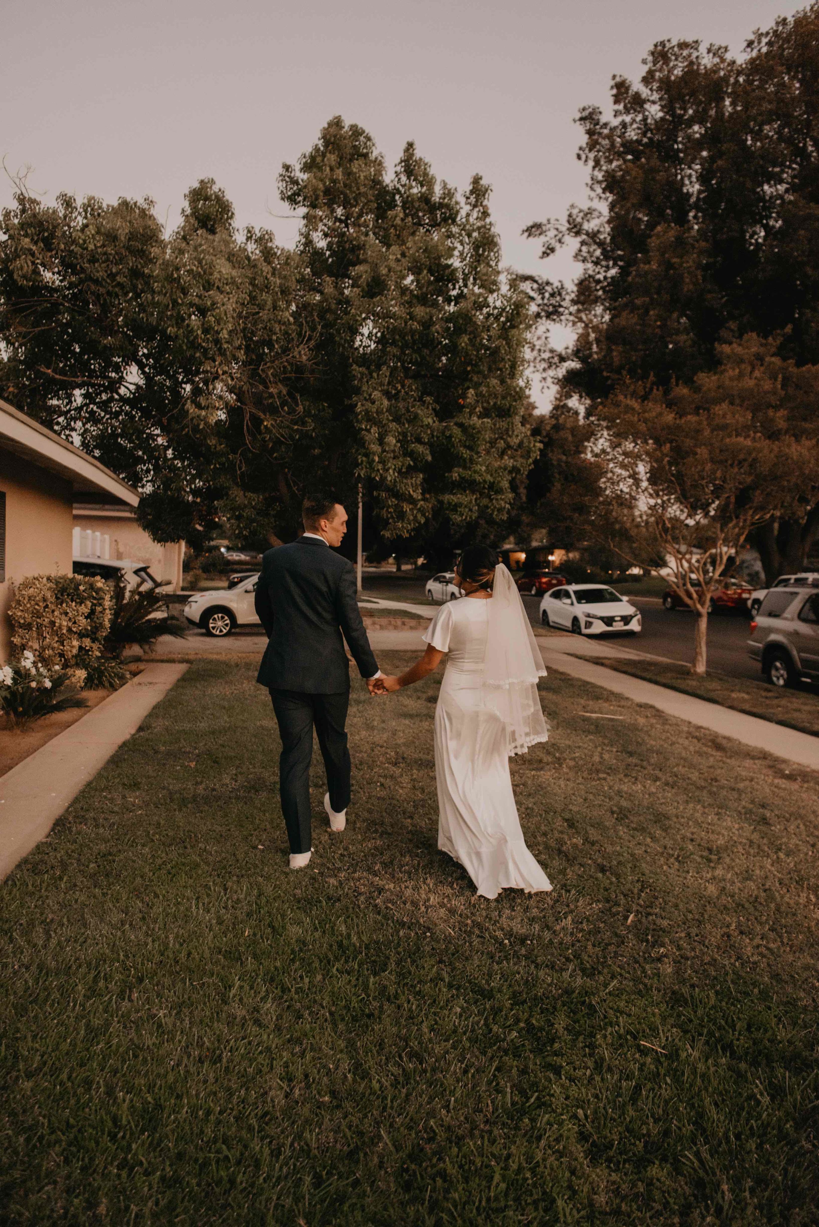 bride and groom walking away holding hands