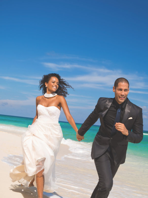 couple running on beach at Sandals Resorts