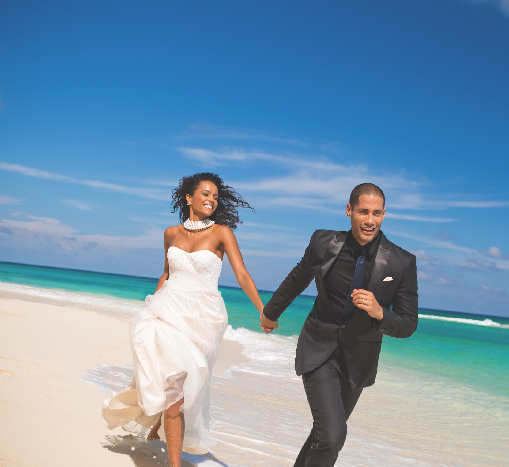 couple running on beach at Sandals Resorts