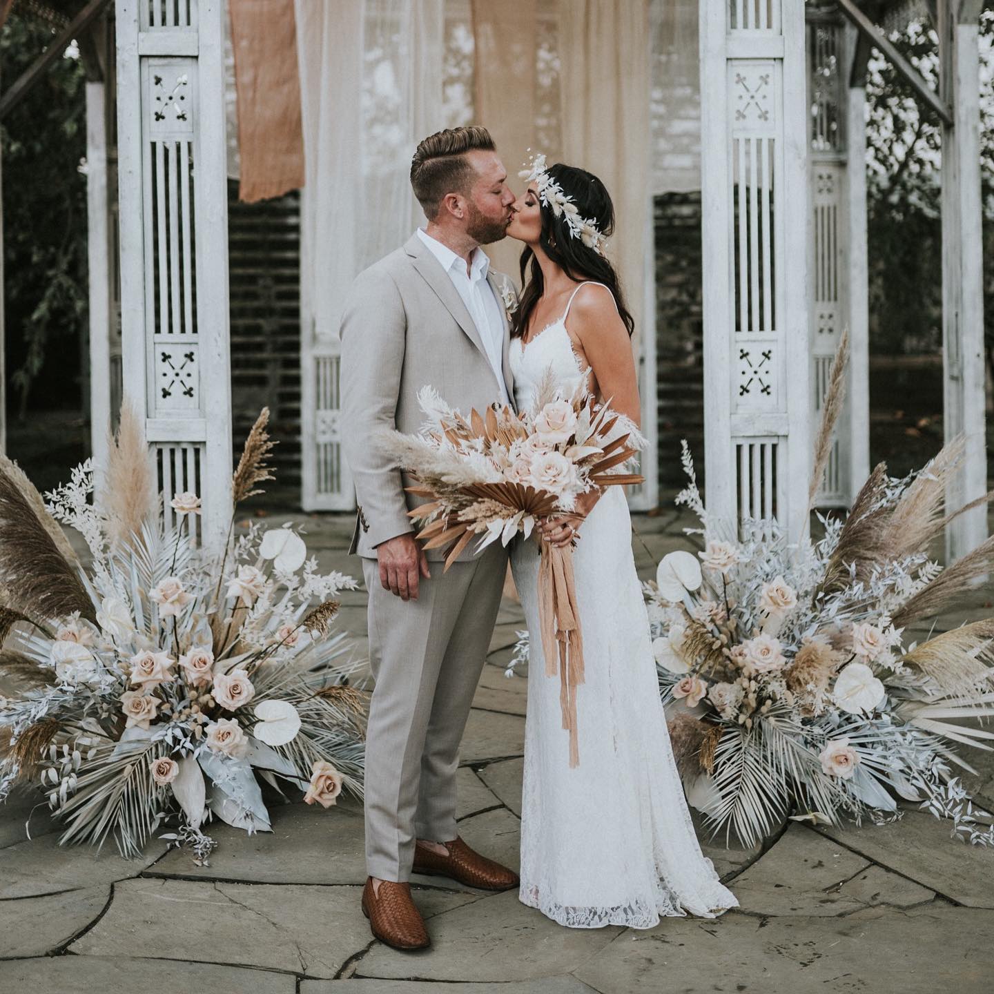 bride and groom kissing at their boho inspired wedding
