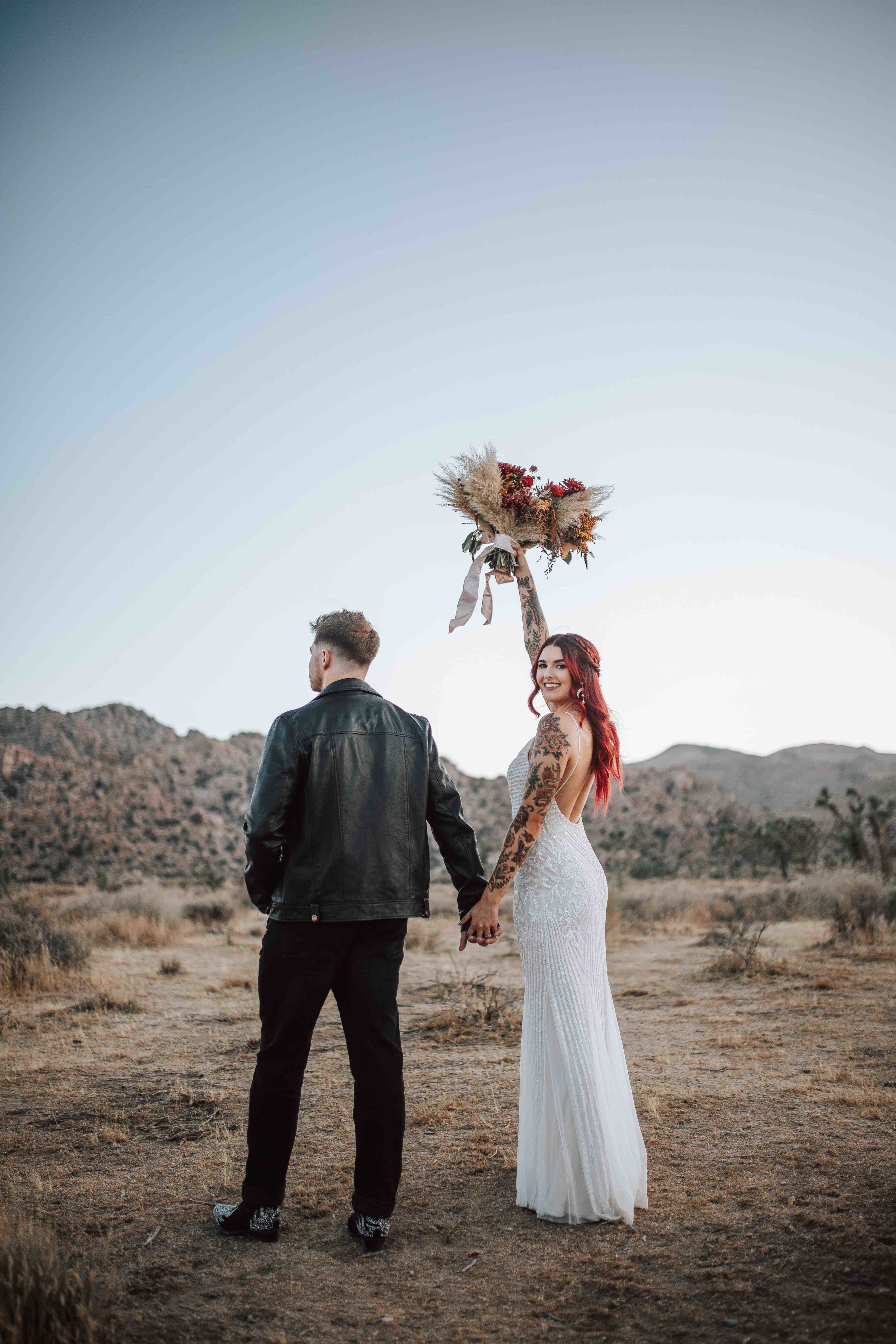 Bride holding bouquet in the air at Joshua Tree National Park