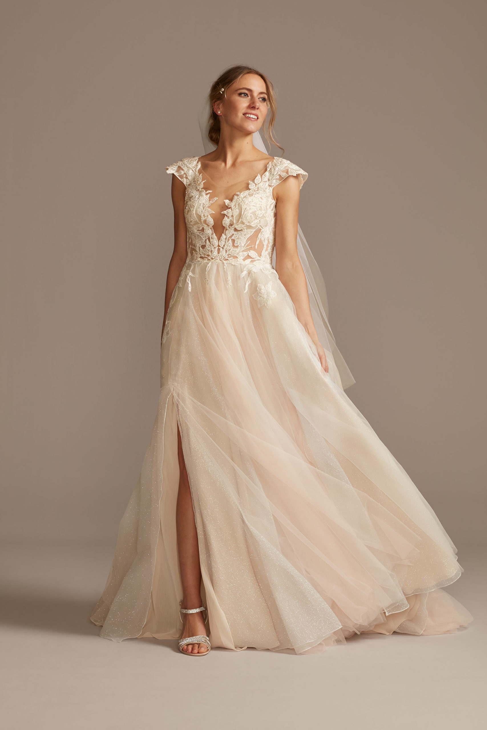 Bride wearing illusion cap sleeve lace appliqued wedding dress